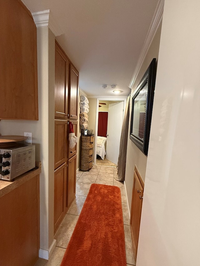 corridor with light tile patterned floors and crown molding