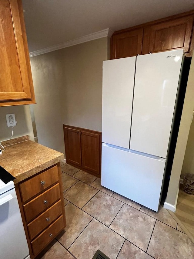 96 Stag Leap Dr, Cleveland, GA 30528 - kitchen with freestanding refrigerator, ornamental molding, brown cabinetry, and light tile patterned flooring