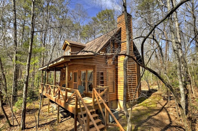 view of home's exterior featuring a wooden deck and a chimney