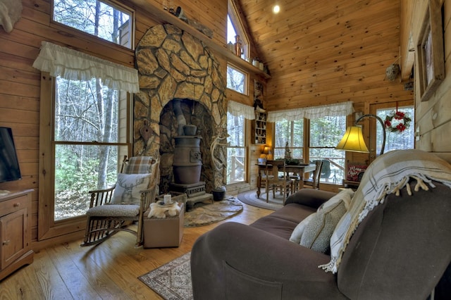 living area featuring wooden ceiling, light wood finished floors, wood walls, and high vaulted ceiling