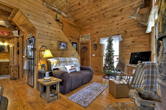 living room featuring wood ceiling, wooden walls, high vaulted ceiling, and wood finished floors