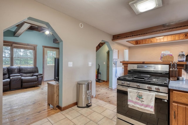 432 Jewell Mason, Blairsville, GA 30512 - kitchen featuring stainless steel gas stove, beam ceiling, brown cabinetry, light wood-style flooring, and open floor plan
