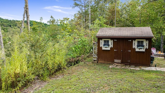 view of shed with a view of trees