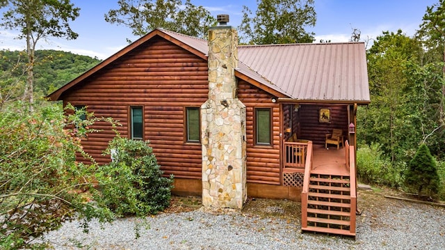 exterior space featuring a chimney and metal roof