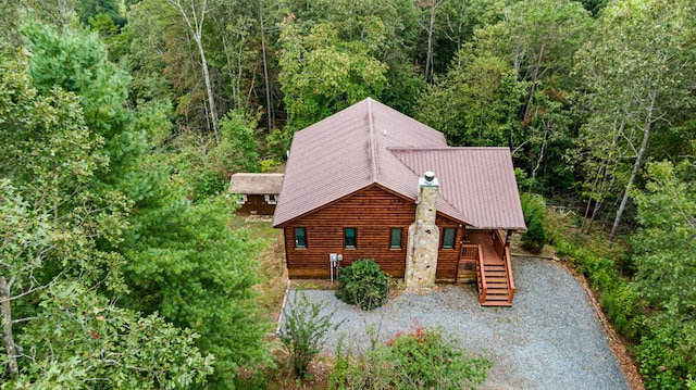 view of front of house with metal roof and a forest view