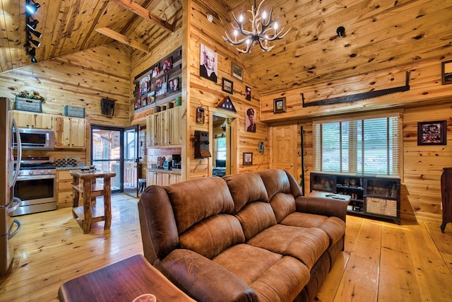 living room featuring high vaulted ceiling, light hardwood / wood-style flooring, and wooden walls