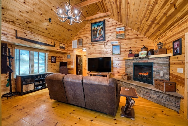 living room with wood walls, wooden ceiling, light hardwood / wood-style flooring, a stone fireplace, and a chandelier