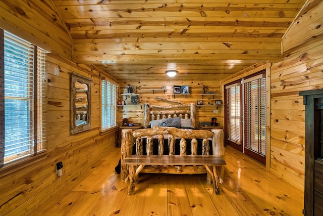 bedroom featuring wood ceiling, vaulted ceiling, hardwood / wood-style flooring, and wooden walls