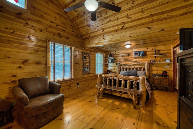 bedroom with high vaulted ceiling, wooden walls, wooden ceiling, and light hardwood / wood-style floors