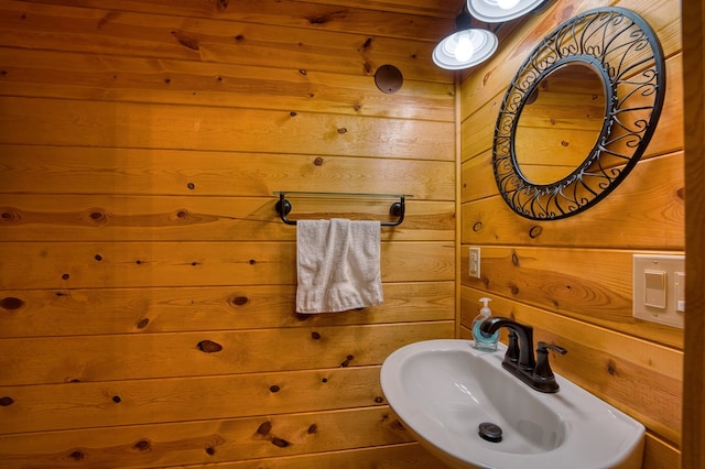 bathroom with wood walls and sink