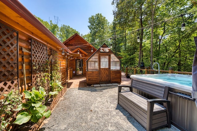 exterior space with a hot tub and a deck