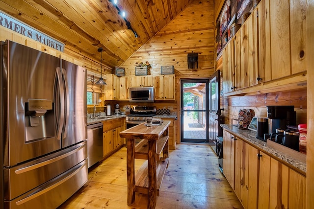 kitchen featuring hanging light fixtures, a wealth of natural light, stainless steel appliances, and stone counters