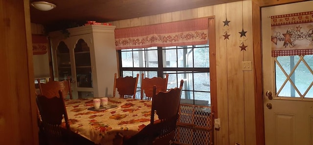 dining area featuring a wealth of natural light and wooden walls