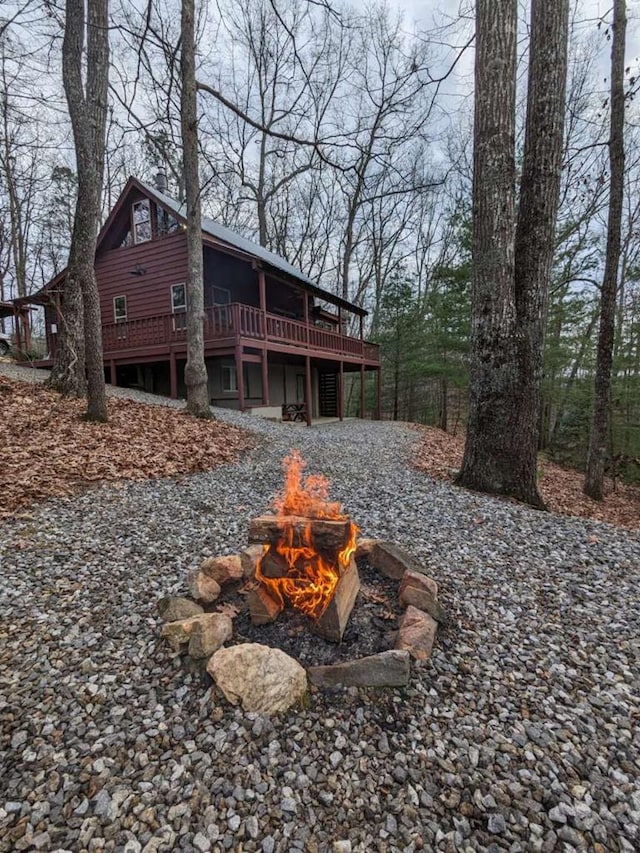 rear view of property with a fire pit and a wooden deck