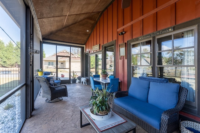 unfurnished sunroom featuring vaulted ceiling and plenty of natural light