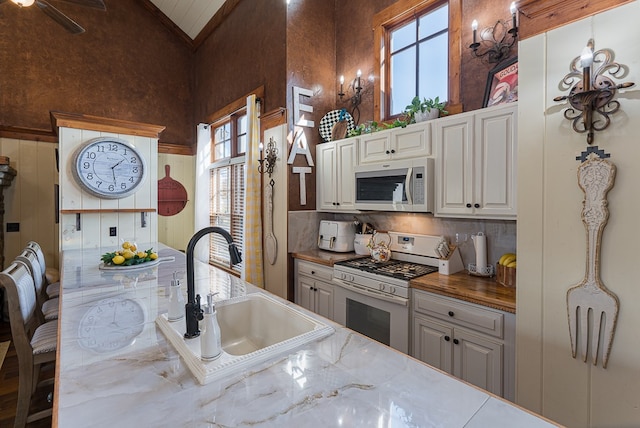 45 Bent Grass Cir, Hayesville, NC 28904 - kitchen with white appliances, a sink, backsplash, light stone countertops, and high vaulted ceiling