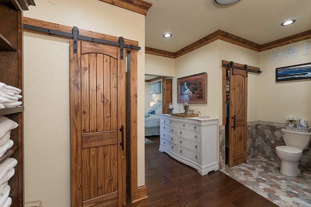 bathroom featuring toilet, hardwood / wood-style floors, ornamental molding, and a textured ceiling