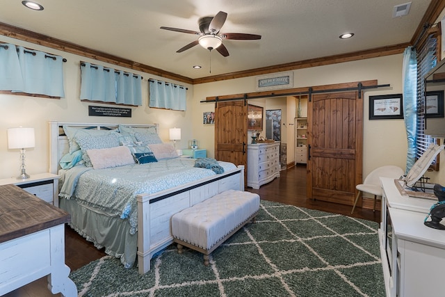 bedroom with a barn door, ceiling fan, a textured ceiling, and dark hardwood / wood-style floors