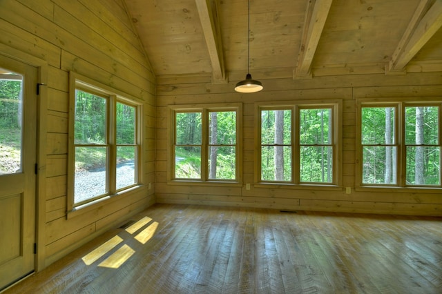 unfurnished sunroom with beam ceiling, a wealth of natural light, and visible vents