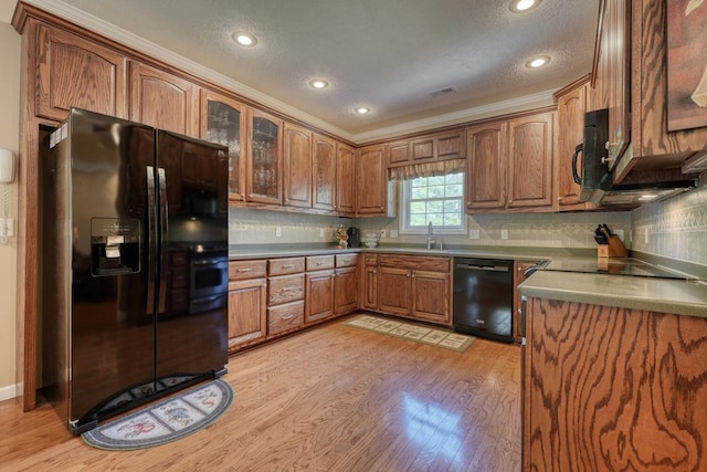 kitchen featuring brown cabinets, light wood finished floors, recessed lighting, tasteful backsplash, and black appliances