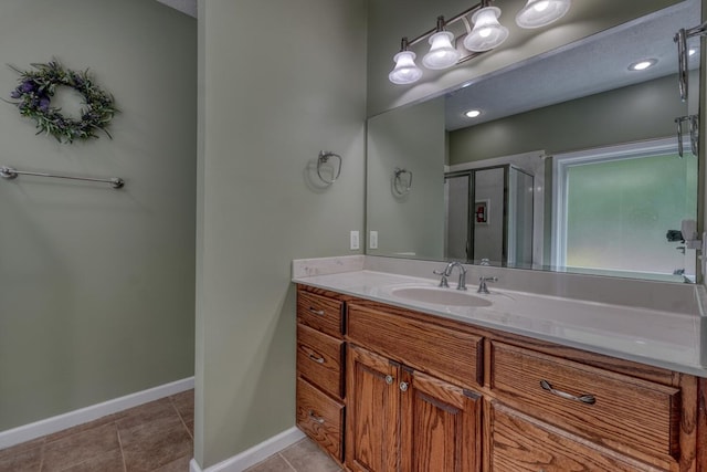 full bath with vanity, tile patterned flooring, baseboards, and a stall shower