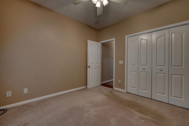 unfurnished bedroom featuring baseboards, carpet, ceiling fan, and a closet