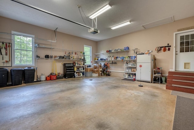 garage with freestanding refrigerator and a garage door opener