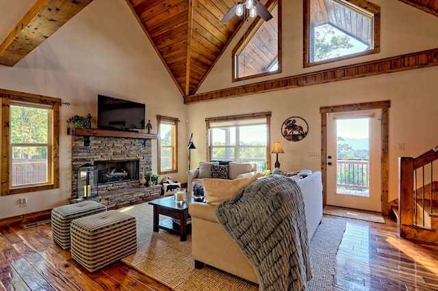 living room with a healthy amount of sunlight, a fireplace, hardwood / wood-style floors, and stairs