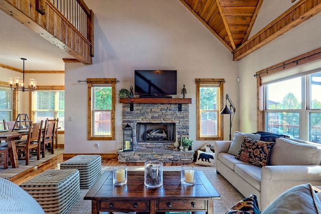 living room with high vaulted ceiling, plenty of natural light, a notable chandelier, and a fireplace