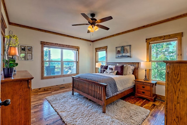 bedroom featuring multiple windows, ornamental molding, and hardwood / wood-style floors