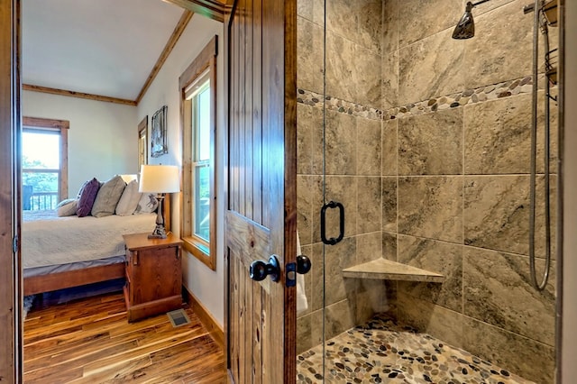 interior space with crown molding, visible vents, ensuite bathroom, a shower stall, and wood finished floors