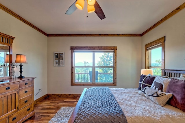 bedroom with dark wood-style floors, ornamental molding, a ceiling fan, and baseboards