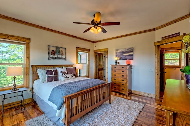 bedroom with ornamental molding, wood finished floors, and baseboards