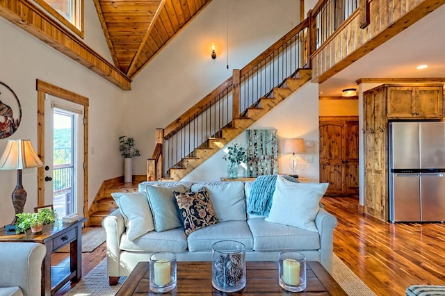 living room featuring stairway, wood finished floors, and a towering ceiling