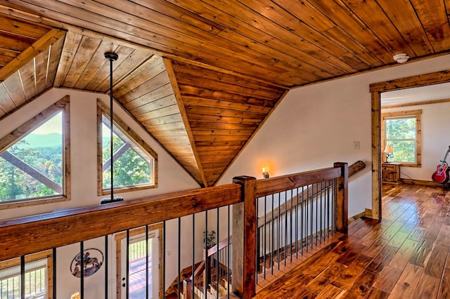 hall featuring a wealth of natural light, wood ceiling, wood finished floors, and an upstairs landing