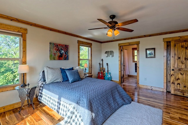 bedroom featuring crown molding, wood finished floors, a ceiling fan, and baseboards