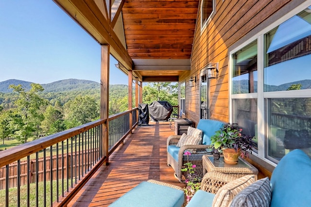 wooden terrace featuring a mountain view and a wooded view