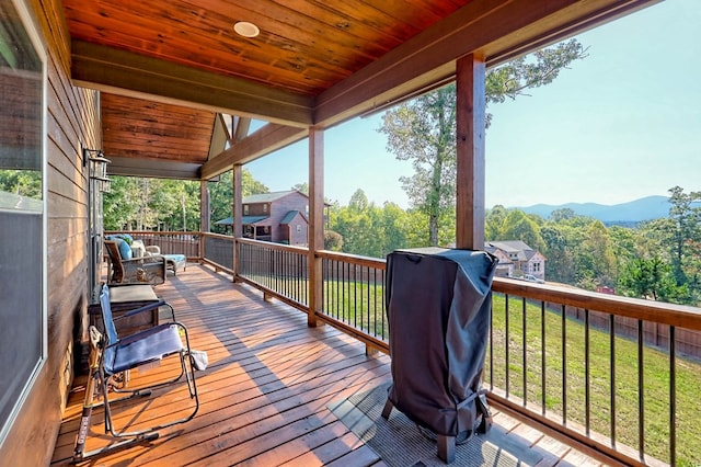 wooden deck with a mountain view and a yard