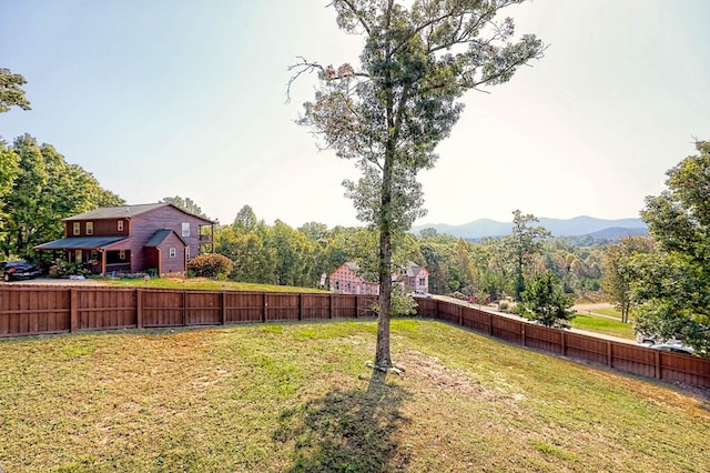 view of yard with fence and a mountain view