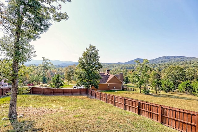 view of yard featuring fence and a mountain view