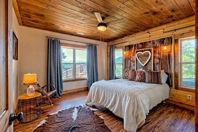 bedroom with wooden ceiling, baseboards, and wood finished floors