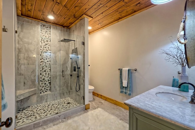 full bathroom featuring toilet, a shower stall, vanity, wooden ceiling, and baseboards