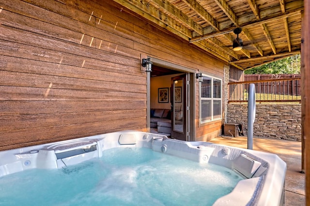 view of patio featuring a hot tub and fence