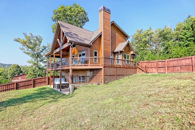 back of house with a lawn, a fenced backyard, a chimney, stairway, and a deck