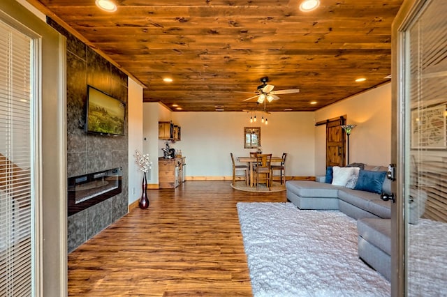 living room featuring a barn door, a tiled fireplace, a ceiling fan, wood ceiling, and wood finished floors