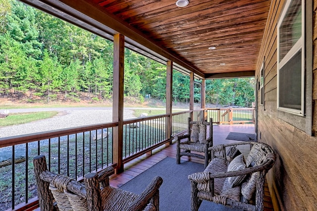 view of patio / terrace featuring covered porch and a view of trees