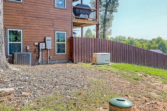 view of home's exterior with cooling unit, a balcony, and fence