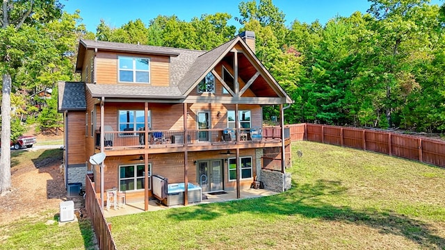 back of property featuring french doors, a chimney, a lawn, a patio area, and a fenced backyard