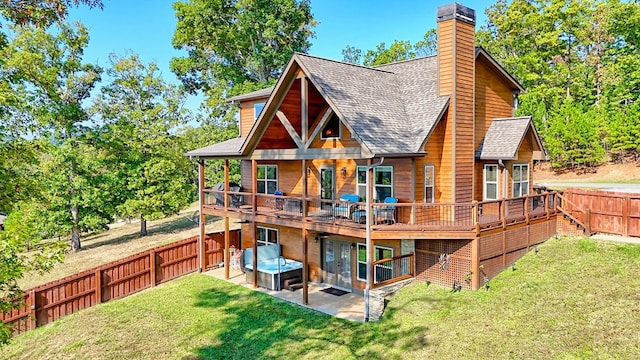 back of property with a lawn, a patio, a fenced backyard, a chimney, and roof with shingles