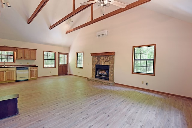 unfurnished living room with high vaulted ceiling, a stone fireplace, and light hardwood / wood-style floors